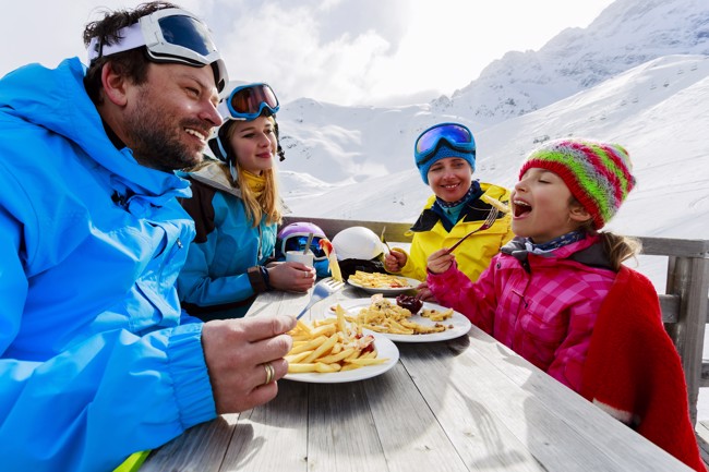 Gezin eet friet op wintersport