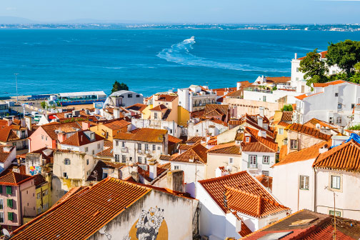 Uitzicht over daken van huizen en de zee in Lissabon tijdens een stedentrip januari