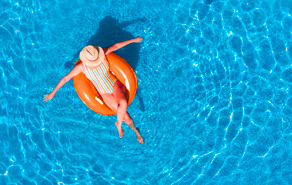 Vrouw in zwembad met oranje zwemband