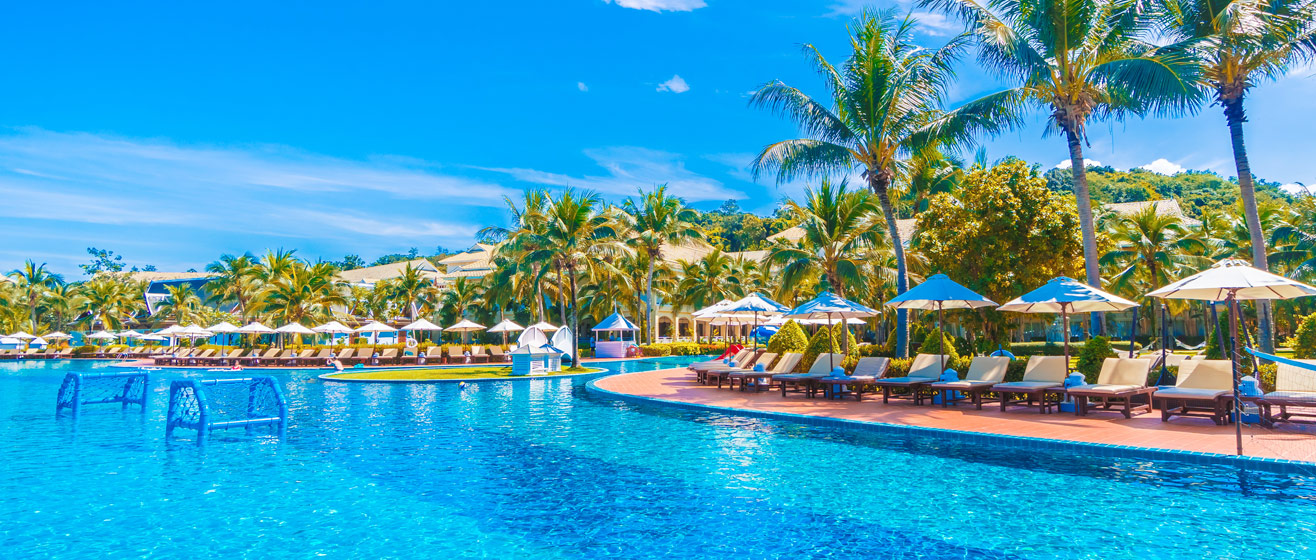 Het zwembad van een luxe hotel omringd door tropische palmbomen