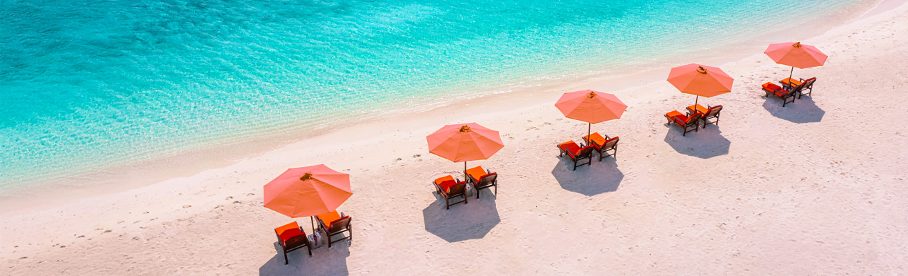 Tropisch strand met ligbedjes en oranje parasols