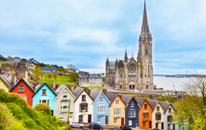 Kleurrijke huisjes en kerkje aan de kust van Ierland