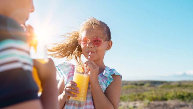 Meisje met zonnebril drinkt drankje op vakantie 2026